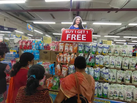Printed 'Buy 1 Get 1 Free' promotional display inside a supermarket