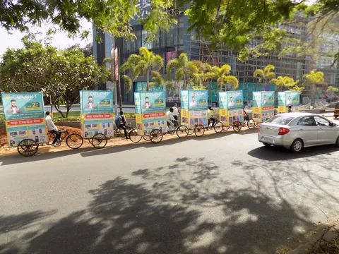 Branded advertising tricycles moving along a city road